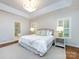 Bright main bedroom with tray ceiling, chandelier, hardwood floors, and ensuite bathroom access at 5816 Valley Stream Trl, Waxhaw, NC 28173