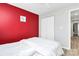 Red bedroom featuring hardwood floors and a door with closet access at 5953 Prescott Ct # 3105, Charlotte, NC 28269