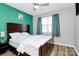 Bright bedroom features a ceiling fan, a window with blue curtains and hardwood floors at 5953 Prescott Ct # 3105, Charlotte, NC 28269