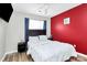 Bedroom with a TV, a window with blue curtains and a vibrant red accent wall at 5953 Prescott Ct # 3105, Charlotte, NC 28269