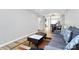 Open living room showcases wood floors, a comfortable gray sofa, and modern coffee table with view to the kitchen at 5953 Prescott Ct # 3105, Charlotte, NC 28269