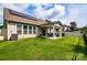 A spacious backyard featuring a covered patio, green lawn, and solar panels on the roof at 6038 Durango Way, Denver, NC 28037