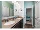 Bathroom with double sinks, dark wood cabinets, and a view to a bedroom at 6038 Durango Way, Denver, NC 28037