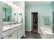 Bathroom featuring double sink vanity, walk-in closet, and soaking tub at 6038 Durango Way, Denver, NC 28037