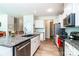 Modern kitchen island featuring granite countertops, stainless steel appliances, and wood vinyl flooring at 6038 Durango Way, Denver, NC 28037