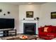 Cozy living room boasting a fireplace, television, and comfortable red sofa at 6038 Durango Way, Denver, NC 28037