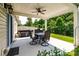 Covered patio with ceiling fan, dining table, hot tub and green backyard at 6038 Durango Way, Denver, NC 28037