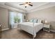 Bright bedroom with a white metal bed frame, patterned pillows, and large window with light-filtering curtains at 73 41St Nw Ave, Hickory, NC 28601
