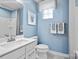 Bright bathroom with blue walls, white cabinets, and modern fixtures at 7335 Childress Dr, Concord, NC 28025