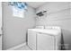 Functional laundry room with modern washer and dryer units and shelving for storage at 7335 Childress Dr, Concord, NC 28025