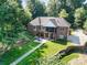 Aerial view of the home with lush landscaping, a patio, and a long driveway leading to the house at 7545 Rabbit Cir, Denver, NC 28037