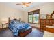 Bedroom with large window letting in natural light, ceiling fan, and wood trim at 7545 Rabbit Cir, Denver, NC 28037