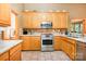 Well-equipped kitchen with stainless steel appliances, wooden cabinets, tile backsplash, and lots of counter space at 7545 Rabbit Cir, Denver, NC 28037