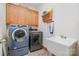 Bright laundry room with washer, dryer, sink, and cabinets offers convenience at 7545 Rabbit Cir, Denver, NC 28037