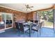 Covered patio with dining table, ceiling fan, and brick wall perfect for outdoor entertaining at 7545 Rabbit Cir, Denver, NC 28037