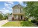 Charming two-story home with a welcoming front porch, well-maintained lawn, and an attached garage at 7642 Rolling Meadows Ln, Huntersville, NC 28078