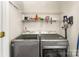 Updated laundry room features modern washer and dryer, wire rack storage and neutral walls at 7642 Rolling Meadows Ln, Huntersville, NC 28078