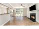 Cozy living room with a fireplace, hardwood floors, and sliding glass doors to the backyard at 7642 Rolling Meadows Ln, Huntersville, NC 28078