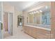 This bathroom features a vanity with marble countertops and a window, with a bright white door to the shower area at 8800 Covey Rise Ct, Charlotte, NC 28226