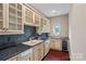 This kitchen has a small sink, a wine cooler, granite countertops, hardwood floors, and lots of storage at 8800 Covey Rise Ct, Charlotte, NC 28226