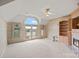 Large, light-filled room with pitched ceiling, fireplace, built-in shelving, and a scenic balcony at 8800 Covey Rise Ct, Charlotte, NC 28226