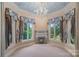 A living room with a fireplace, carpeted floors, custom curtains, high ceilings, and lots of natural light at 8800 Covey Rise Ct, Charlotte, NC 28226