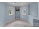 A cozy blue sitting room provides natural light via two oval windows and a wall-mounted television at 8800 Covey Rise Ct, Charlotte, NC 28226