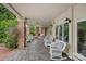 Inviting covered porch with brick columns and multiple seating areas at 8800 Covey Rise Ct, Charlotte, NC 28226