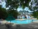Take a dip in the refreshing community pool surrounded by lush greenery, with lounge chairs and a shaded table at 9139 Charminster Ct, Charlotte, NC 28269