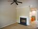 Bright living room featuring a fireplace, ceiling fan, and view of the kitchen at 9139 Charminster Ct, Charlotte, NC 28269