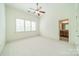 Bright bedroom has neutral carpet, a ceiling fan, and a view into the attached bathroom at 9202 Arlington Hills Dr, Mint Hill, NC 28227
