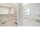 Spacious walk-in closet features custom shelving and ample storage space and a window for natural light at 9202 Arlington Hills Dr, Mint Hill, NC 28227