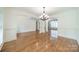 Open-concept dining room with an elegant chandelier, hardwood floors, and white trim at 9202 Arlington Hills Dr, Mint Hill, NC 28227