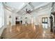 Open-concept living room featuring hardwood flooring, coffered ceiling, and seamless flow to other rooms at 9202 Arlington Hills Dr, Mint Hill, NC 28227