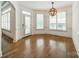 Bright room with hardwood floors, large windows with shutters, and a stylish lighting fixture at 9202 Arlington Hills Dr, Mint Hill, NC 28227