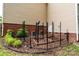 View of a fenced garden and exterior with vibrant greenery, brick accents, and AC units at 9410 Greenbank Ct, Charlotte, NC 28214
