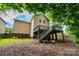 The backyard features a wood deck with stairs and a mulched area, surrounded by lush greenery and mature trees at 9410 Greenbank Ct, Charlotte, NC 28214