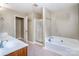 Bright bathroom with double vanity, glass shower, and a soaking tub at 9410 Greenbank Ct, Charlotte, NC 28214