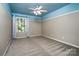Bedroom features a blue accent and a large window with natural light at 9410 Greenbank Ct, Charlotte, NC 28214