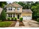 Charming two-story home with a manicured lawn and a two-car garage with mature landscaping at 9410 Greenbank Ct, Charlotte, NC 28214