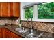 A stainless steel kitchen sink is set under a window to the backyard at 9410 Greenbank Ct, Charlotte, NC 28214