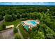 An aerial view of a community pool featuring a slide, lounging area, and well-maintained landscaping surrounded by mature trees at 9410 Greenbank Ct, Charlotte, NC 28214