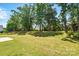 A lush green backyard with mature trees and partial fencing on a sunny day at 1005 Exodus Ct, Monroe, NC 28110