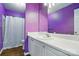 Bright bathroom featuring purple walls, a white vanity, and a shower with a white curtain at 1005 Exodus Ct, Monroe, NC 28110