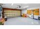 Spacious garage with an automatic door, pegboard, epoxy flooring, and ample storage space at 1005 Exodus Ct, Monroe, NC 28110