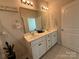 Modern bathroom featuring double sinks, white cabinetry, and updated lighting fixtures at 1016 Laggan Ln, Indian Trail, NC 28079