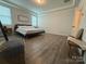 Bright bedroom featuring hardwood floors, a wooden bench, and neutral walls at 1016 Laggan Ln, Indian Trail, NC 28079