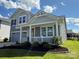 Charming two-story home with gray siding, stone accents, a covered porch, and a well manicured lawn at 1016 Laggan Ln, Indian Trail, NC 28079
