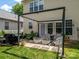 Cozy backyard patio under a pergola, featuring stylish seating and a barbecue grill, ideal for relaxation at 10639 Secret Garden Ln, Charlotte, NC 28214