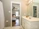 Bright bathroom featuring a double sink vanity with white cabinets and an open doorway view into the bedroom at 10639 Secret Garden Ln, Charlotte, NC 28214
